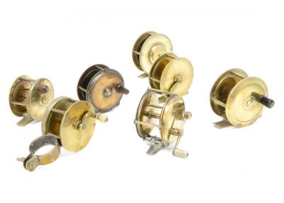 A group of seven vintage brass fishing reels, including an Army