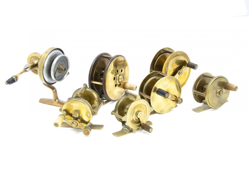 A group of seven vintage brass fishing reels, including an Army & Navy CSL  2, a Jardine Heaton brass & lacquered patent 18817, 3, an Illingworth  No.3 casting reel, a DAM Effzett